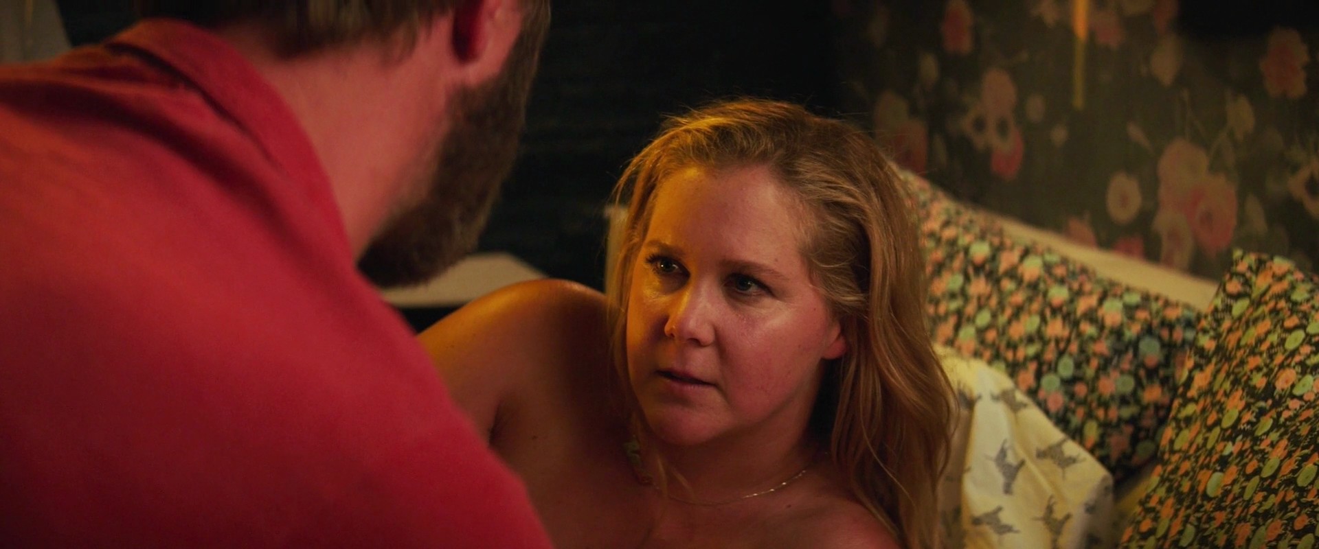 Amy Schumer appears nude behind a man when we first get an out-of-focus gli...