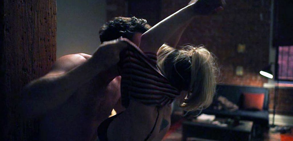 Here, Kaley Cuoco is kissing a man while he removes her shirt, revealing he...
